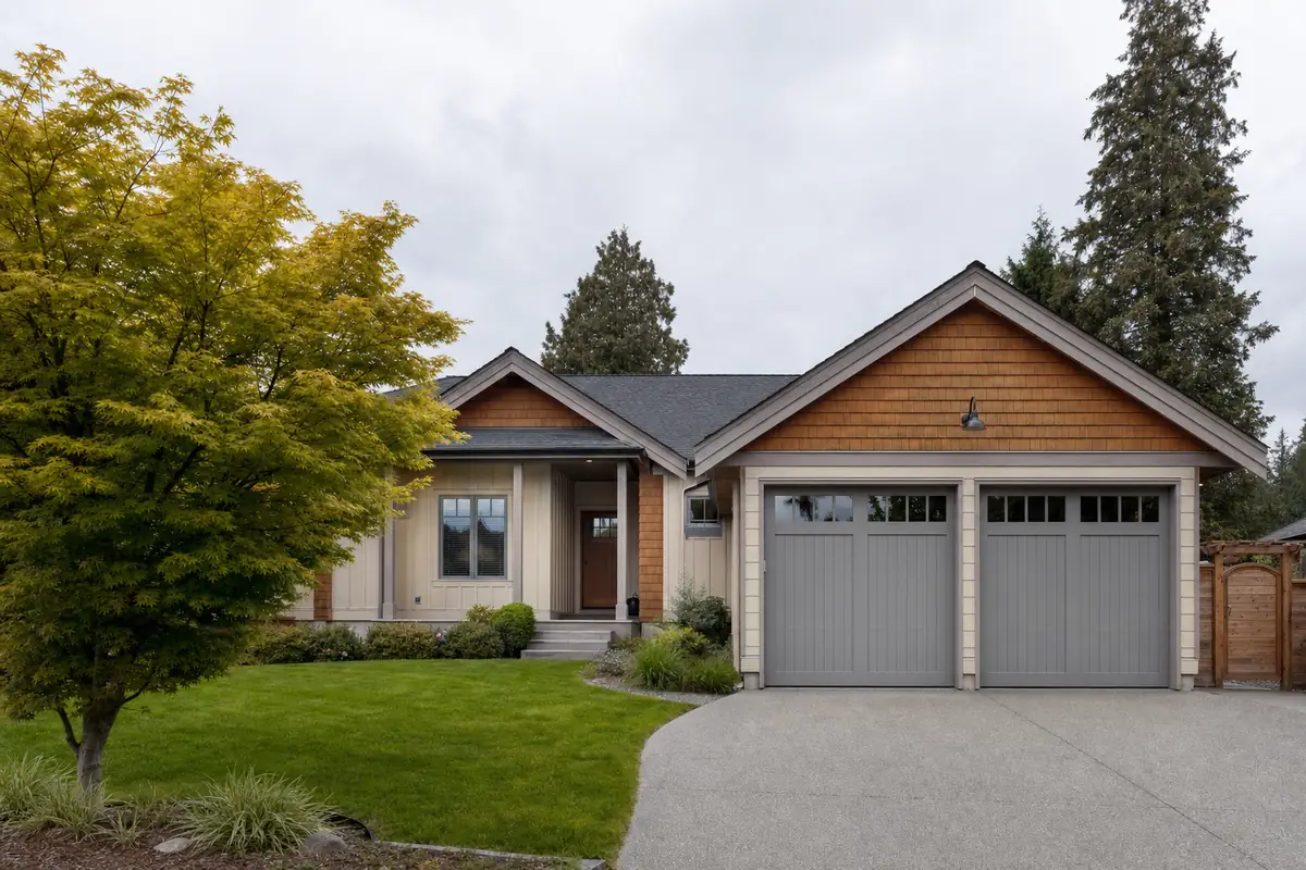 A dark grooved-panel garage door on a well-lit Vancouver driveway
